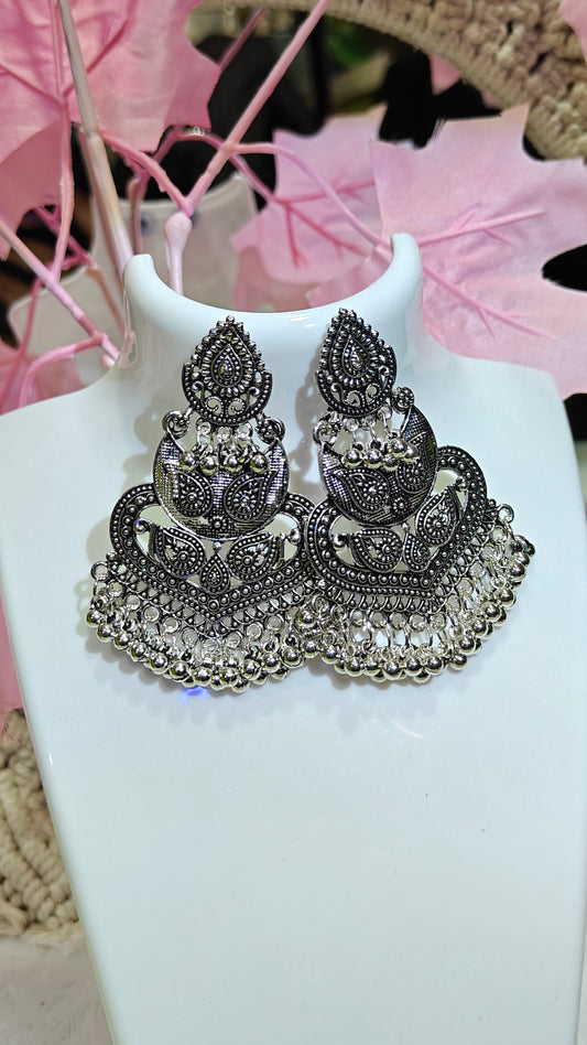 intricately crafted oxidized silver earrings,shimmering with detailed patterns and dangling silver beads at Dilverse